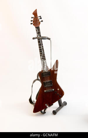 Petit modèle sur un support de guitare sur un fond blanc. Banque D'Images