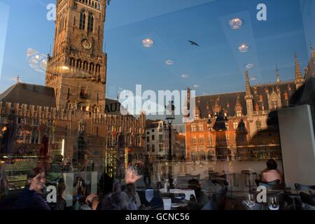 Reflet dans un restaurant verre de Grote Markt, à la tombée du soir et Belfort van Brugge Banque D'Images