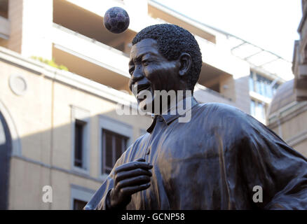 Football - coupe du monde de la FIFA 2010 Afrique du Sud - les fans se préparent.Un ballon de football rebondit sur une statue de Nelson Mandela sur la place Nelson Mandela, à Sandton, en Afrique du Sud Banque D'Images