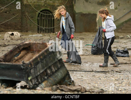 Les membres de Surfers Against Seégouts et Thames 21 nettoient les rives de la Tamise, près du pont de Battersea dans le sud-ouest de Londres, dans le cadre de la visite de Surfers Against Seégouts du 20e anniversaire de la Beach Clean Tour, qui a visité 20 plages et sites au bord de l'eau du Royaume-Uni. Banque D'Images