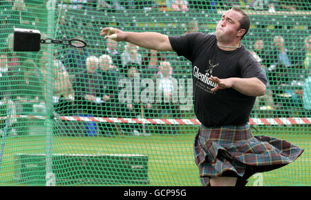 Un concurrent participe à l'épreuve de poids à distance de 56 livres aux Jeux du Braemar Highland à Braemar, en Écosse. Banque D'Images