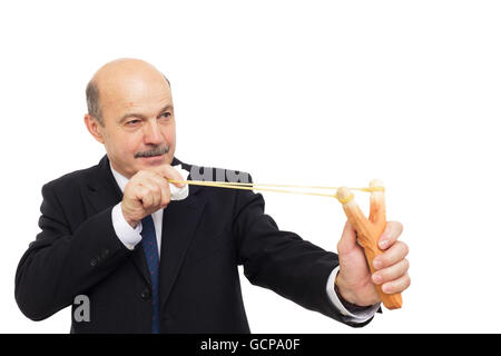 Personnes âgées businessman en costume avec slingshot tir papier froissé Banque D'Images