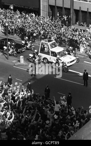 Les foules applaudissent et agitent pour accueillir le pape Jean-Paul II, alors qu'il descend la rue Victoria dans son « Popemobile » sur la route de la cathédrale de Westminster. Banque D'Images