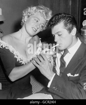 Film - Tony Curtis et Shelley Winters - Los Angeles, Etats-Unis.L'actrice américaine Shelley Winters allume une cigarette pour l'acteur Tony Curtis. Banque D'Images