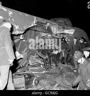 Les secouristes tentent d'atteindre les victimes piégées par un trou béant sur le toit d'un autocar allongé sur les côtés après l'accident du train à la mousse Green, Londres. Banque D'Images