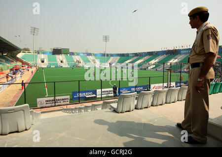 Un agent de sécurité regarde la vue du stade pratiquement vide lors du match de hockey préliminaire entre le Pakistan et l'Écosse au cours du deuxième jour des Jeux du Commonwealth de 2010 au stade national du Major Dhyan Chand à New Delhi, en Inde. Banque D'Images