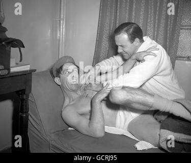 Essayer d'éviter la masseuse Frank Duffett est le comédien Norman Wisdom, qui apparaît actuellement dans la revue « Paris à Piccadilly » au Prince of Wales Theatre. Après chaque performance Norman a tout à fait quelques rayures, bosses et muscles fatigués que Frank Duffett prend soin de s'il peut l'épingler assez longtemps. Banque D'Images