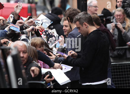 Robbie Williams (à droite) et Gary Barlow (à gauche du centre) de prendre cette sortie de radio 1 dans le centre de Londres. Banque D'Images