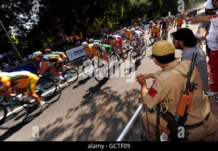 Sport - Jeux du Commonwealth 2010 - septième jour - Delhi.La sécurité regarde les cavaliers pendant la course de route masculine de 168 km pendant le septième jour des Jeux du Commonwealth 2010 à New Dehli, Inde. Banque D'Images