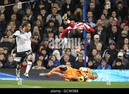 Danny Welbeck de Sunderland (en haut) dépasse le gardien de but Heurelho de Tottenham Hotspur Gomes (plancher) comme le regarde Benoit Assou-Ekotto (gauche) de Tottenham Hotspur Banque D'Images