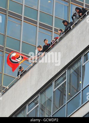 Des manifestants sur le toit de la Millbank Tower, à Westminster, dans le centre de Londres, tandis que des étudiants et des enseignants se sont rassemblés dans le centre de Londres pour protester contre les réductions de financement des universités et le gouvernement prévoit de facturer jusqu'à 9,000 000 frais par an à partir de 2012. Banque D'Images