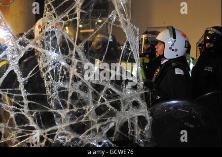 La police entre sur le front détruit de la Millbank Tower, à Westminster, Londres, après que des étudiants et des enseignants se sont réunis pour protester contre les réductions de financement des universités et que le gouvernement envisage de facturer jusqu'à 9,000 000 frais par an à partir de 2012. Banque D'Images