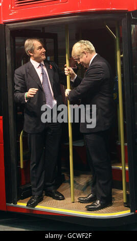 Le secrétaire d'État pour l'Irlande du Nord Owen Paterson (à gauche) regarde le maire de Londres Boris Johnson briser accidentellement un poteau lors du dévoilement d'une maquette grandeur nature du nouveau bus à impériale à arrêts multiples pour Londres, basé sur le chauffeur et chef d'orchestre Routemaster à Acton, dans l'ouest de Londres. Banque D'Images