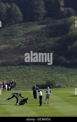 Le Padraig Harrington (au centre) d'Europe prend un coup de feu tandis que son coéquipier Ian Poulter se met en avant pour éviter qu'un sac de golf ne tombe. Banque D'Images