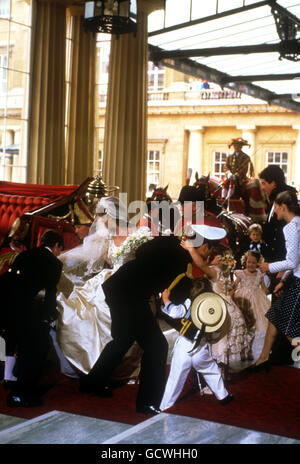 Le duc d'York est submergé par le prince William, pageboy, et la demoiselle d'honneur Zara Phillips, regardées par une autre demoiselle Laura Fellowes et le pageboy Peter Phillips, tandis que sa mariée la duchesse d'York est aidée par son train du Landau d'État de 1902 à son arrivée au Palais de Buckingham. Banque D'Images