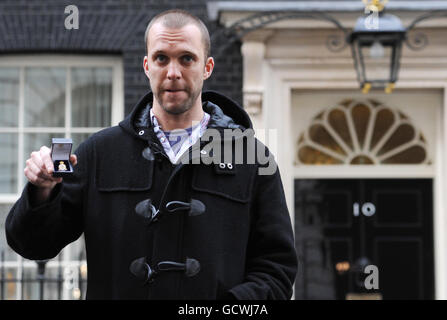 L’ancien soldat et militant anti-guerre Joe Glenton, emprisonné pour avoir refusé de rentrer en Afghanistan, détient ses médailles militaires avant de les remettre au 10 Downing Street à Londres. Banque D'Images