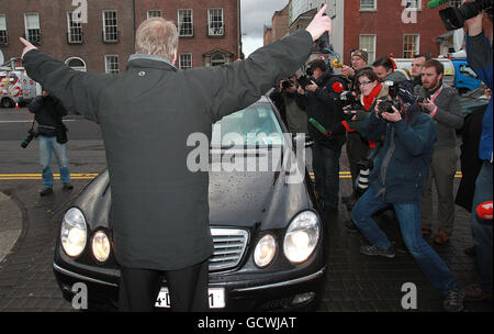 Un manifestant bloque l'entrée alors que la ministre du Tourisme, de la Culture et du Sport Mary Hanafin s'approche des bâtiments gouvernementaux à Dublin, alors que le cabinet rencontre le ministre irlandais des Finances Brian Lenihan pour demander au gouvernement de demander un prêt de sauvetage au Fonds monétaire international (FMI) et à l'Europe. Banque D'Images