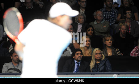 Diego Maradona et sa petite amie Veronica Odeja regardent comme le Novak Djokovic de Serbie rivalise contre Tomas Berdych de la République tchèque (à gauche) pendant la deuxième journée des finales du Barclays ATP World tennis Tour à l'O2 Arena, Londres. Banque D'Images