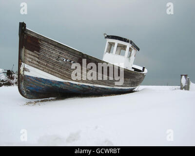 Un bateau se trouve sur une plage enneigée à Eastbourne, dans l'est du Sussex, tandis que la neige continue de tomber à travers le Royaume-Uni. Banque D'Images