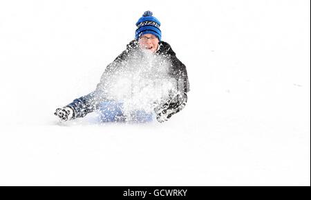 Les enfants apprécient la neige au parc Kelvingrove, à Glasgow, tandis que le grand gel resserre son emprise sur la nation. Banque D'Images