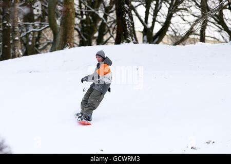 Les habitants de la région apprécient la neige à Kelvingrove Park, à Glasgow, tandis que le grand gel resserre son emprise sur la nation. Banque D'Images