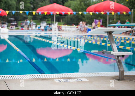 Un bloc de plongée se tient devant les voies de course vide dans une piscine Banque D'Images