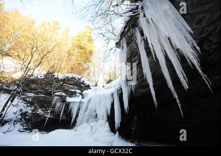 Un homme regarde les glaces de la grotte de Gibsons à Bowles, Teesdale, alors que les conditions météorologiques hivernales continuent d'attraper le Royaume-Uni. Banque D'Images