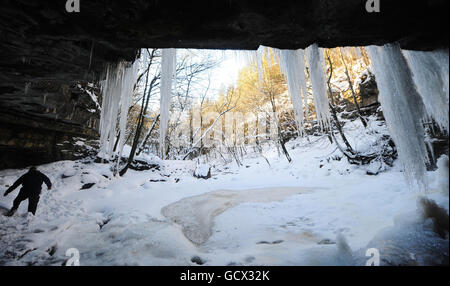 Un homme regarde les glaces de la grotte de Gibsons à Bowles, Teesdale, alors que les conditions météorologiques hivernales continuent d'attraper le Royaume-Uni. Banque D'Images