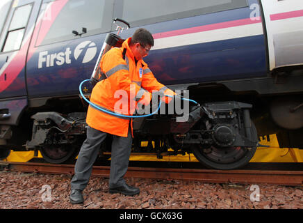 Le nouveau ministre écossais des Transports, Keith Brown, utilise un spray de dégivrage « Kill Frost » qui empêche et facilite le retrait de la glace du train de roulement d'un train lors d'une visite au dépôt Eastfield de ScotRail à Glasgow. Banque D'Images