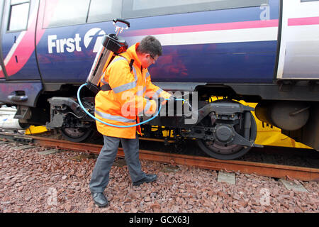 Le nouveau ministre écossais des Transports, Keith Brown, utilise un spray de dégivrage « Kill Frost » qui empêche et facilite le retrait de la glace du train de roulement d'un train lors d'une visite au dépôt Eastfield de ScotRail à Glasgow. Banque D'Images