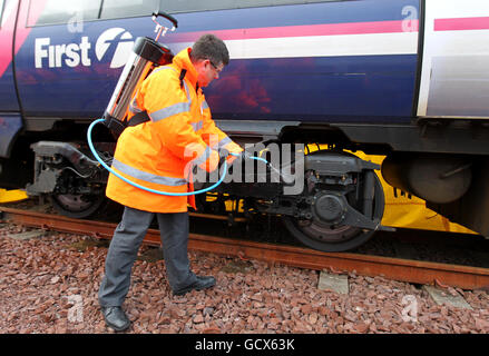 Le nouveau ministre écossais des Transports, Keith Brown, utilise un spray de dégivrage « Kill Frost » qui empêche et facilite le retrait de la glace du train de roulement d'un train lors d'une visite au dépôt Eastfield de ScotRail à Glasgow. Banque D'Images