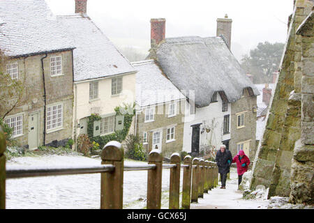 Un couple se rend lentement sur Gold Hill à Shaftesbury, Dorset, alors que les météo prédisaient que de fortes tempêtes de neige frapperaient presque toutes les parties du Royaume-Uni pendant le week-end. Banque D'Images