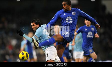 Football - Barclays Premier League - Manchester City / Everton - City of Manchester Stadium.Carlos Tevez (à gauche) de Manchester City et Sylvain Distin (à droite) d'Everton se battent pour le ballon. Banque D'Images