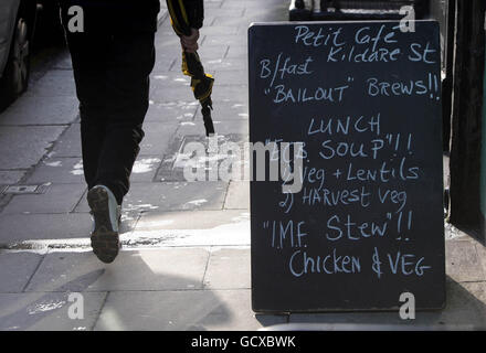 Les difficultés financières de l'Irlande.Ce matin, un homme passe devant un menu à thème de sauvetage au petit Cafe de Dublin. Banque D'Images