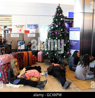 Les passagers attendent des informations sur les vols retardés et annulés dans le terminal 4 de l'aéroport Heathrow de Londres, car les conditions météorologiques hivernales ont continué de causer des problèmes de transport. Banque D'Images