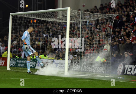 Stephen Bywater, gardien de but du comté de Derby, lance une bombe à fumée lancée sur le terrain lors du match du championnat npower au City Ground, à Nottingham. Banque D'Images