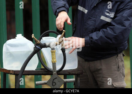 Un employé de Northern Ireland Water remplit des conteneurs en plastique pour les membres du public à l'extérieur du siège social de l'entreprise à North Belfast. Banque D'Images