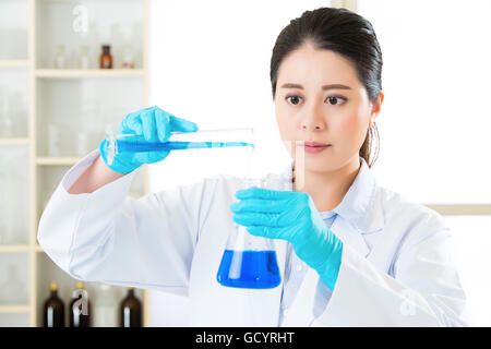 Jeune chercheur asiatique bravant les nouvelles frontières de la médecine avec des gants de laboratoire Banque D'Images