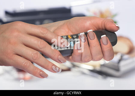 Les mains avec French manucure de garder le combiné Banque D'Images