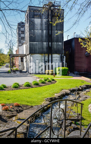 Donnant sur la grotte ornée de printemps pont métallique à vieux moulin du grain des structures, la distillerie Jack Daniel dans la région de Lynchburg, TN Banque D'Images