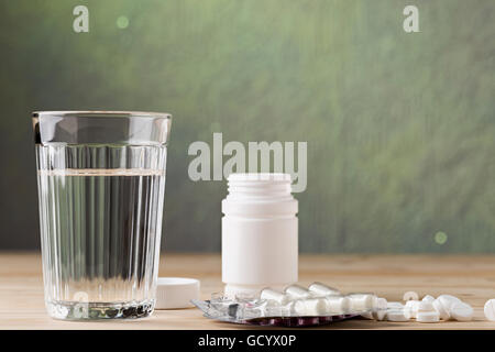 Verre de l'eau propre et comprimé blister on wooden table Banque D'Images