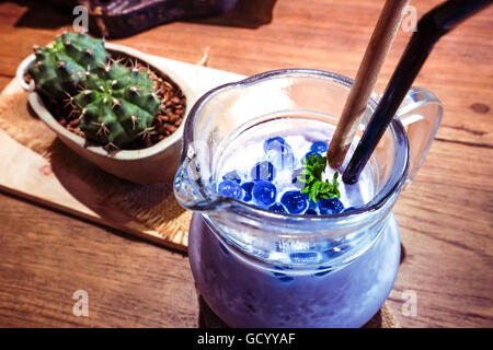 Frappé aux bleuets à la menthe en pot Mason tasse avec paille et cactus. Voir ci-dessus sur le bois. Banque D'Images