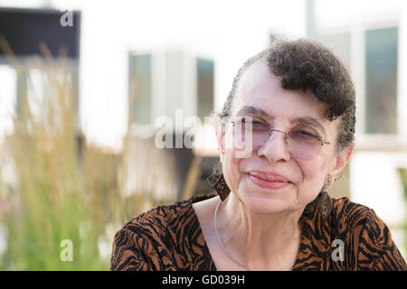 Closeup portrait portrait, grand-mère avec des lunettes, smiling, fond plein air isolé Banque D'Images