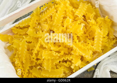 Pâtes farfalle papillon non cuits dans une boîte en bois Banque D'Images