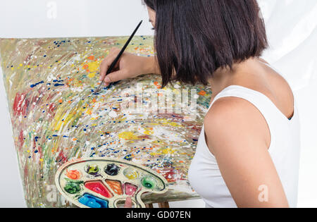 Jeune femme avec un chevalet peint un tableau Banque D'Images