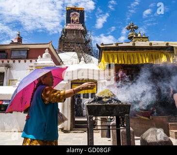 Femme priant devant Stupa Boudhanath Banque D'Images