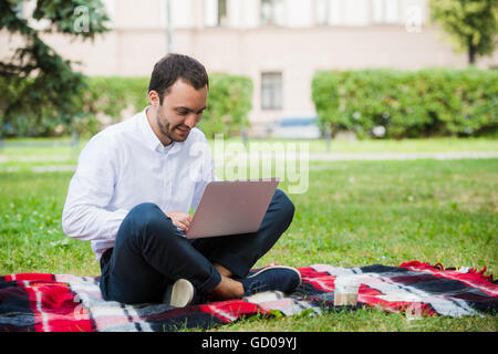 Homme sérieux sur le terrain. Avec l'ordinateur portable Banque D'Images