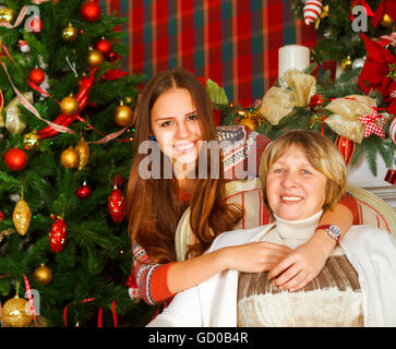Portrait d'une grand-mère et petite-fille de l'adolescence près de l'arbre de Noël d'être heureux et joyeux Banque D'Images