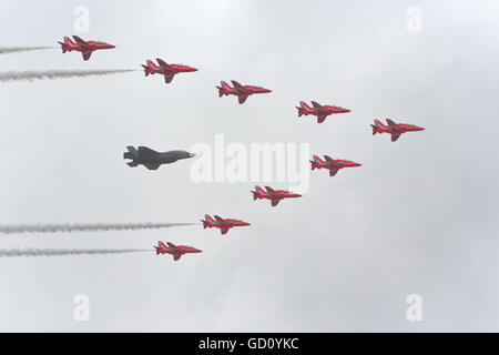 Farnborough, Hampshire, Royaume-Uni. 11 juillet, 2016. Farnborough International Airshow. Défilé d'un Lockheed Martin F35 accompagné par les flèches rouges Crédit : Uwe Deffner/Alamy Live News Banque D'Images