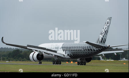 Farnborough, Hampshire, Royaume-Uni. 11 juillet 2016. Premier vol de l'Airbus A350 en vertu de l'assombrissement du ciel. Jour de l'ouverture du commerce international de Farnborough Airshow où le major international aviation et aérospatiale est signée. Le salon se déroule du 11 au 15 juillet et englobe des entreprises et de la défense civile, Aviation, l'espace, à voilure tournante et la fabrication. Le public de l'aéronautique se déroule du 16 et 17 juillet. Credit : aviationimages/Alamy Live News. Banque D'Images